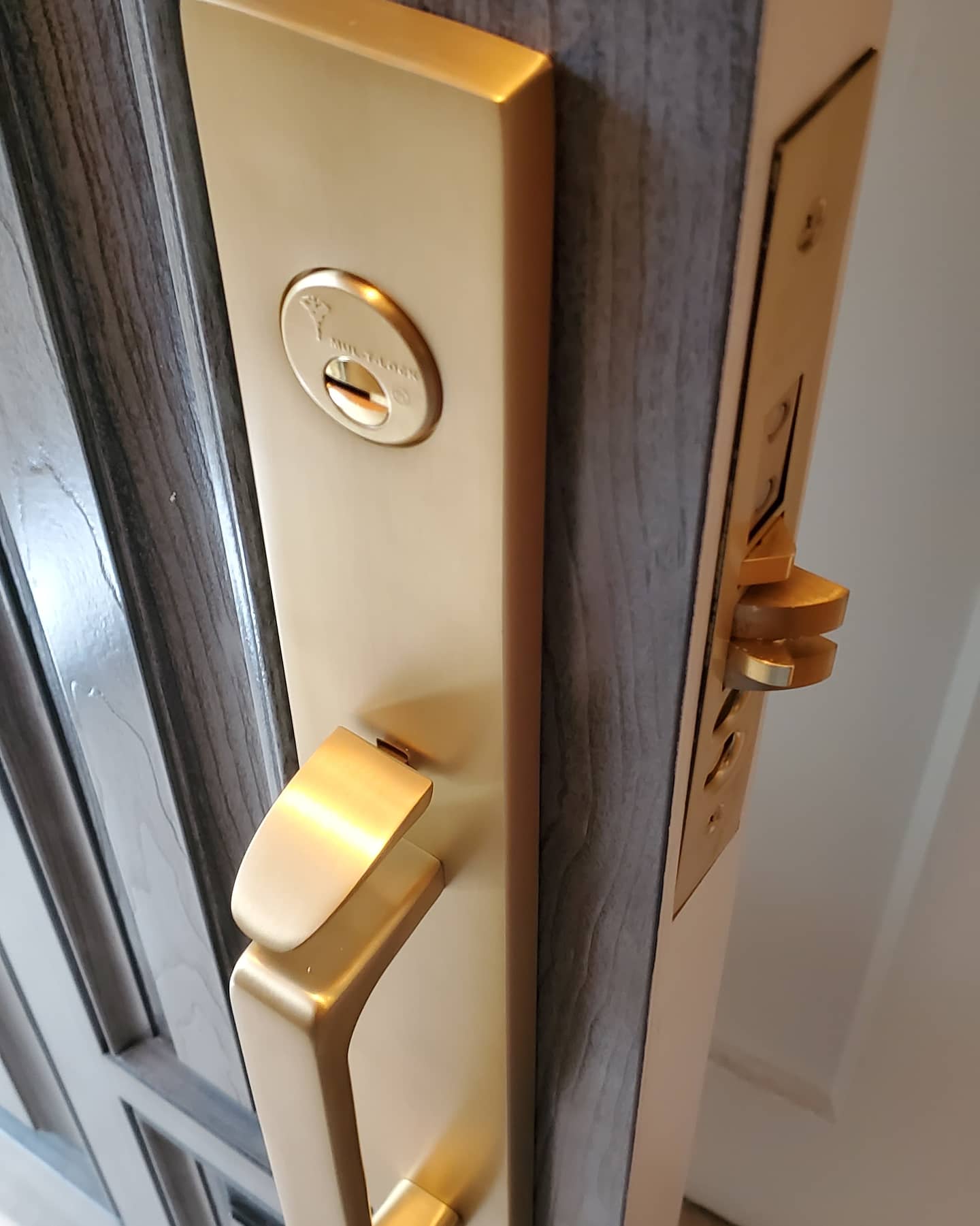 Brass mortise lock and handle installed on an entry door